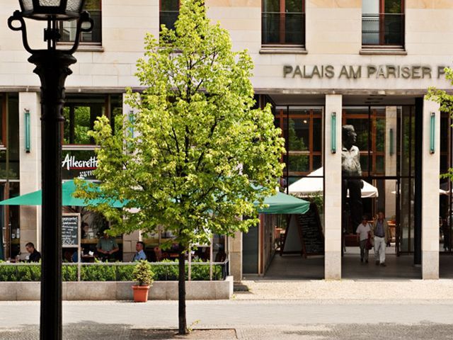Eleganter Pariser Platz mit Café „Palais am Pariser Platz“ und grünem Baum vor Fassade.