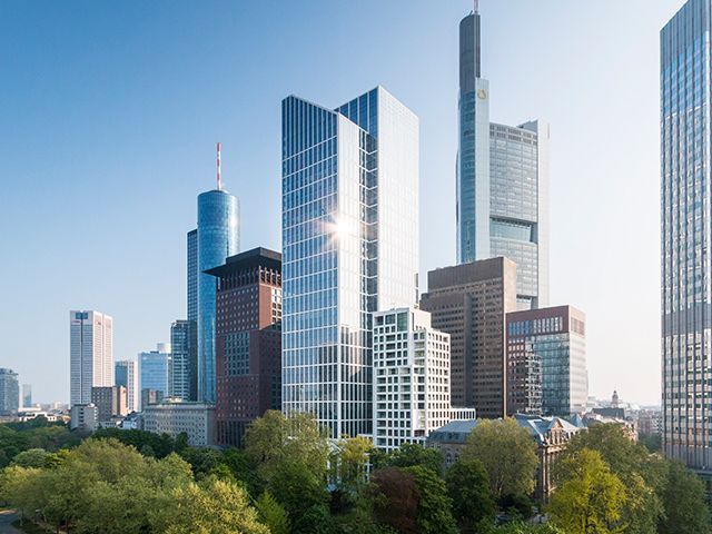 Moderne Wolkenkratzer in Frankfurt am Main bei Sonnenschein, urbaner Skyline mit Grünflächen.