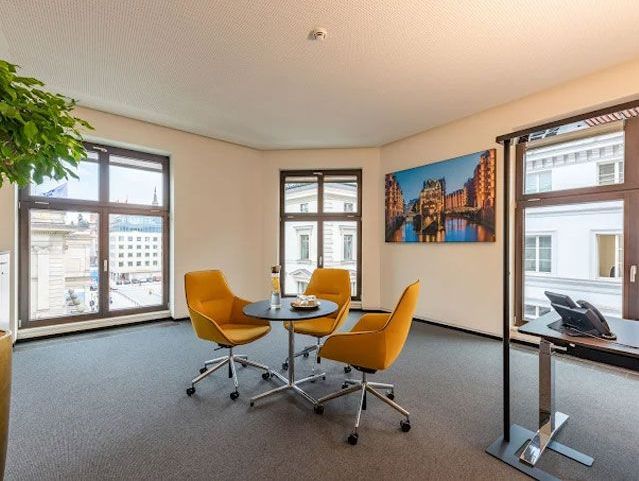 Moderner Besprechungsraum mit Tisch, Stühlen und Stadtblick durch große Fenster.