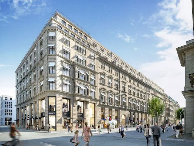 Moderne Stadtarchitektur mit belebter Fußgängerzone und luxuriösen Geschäften unter klarblauem Himmel.